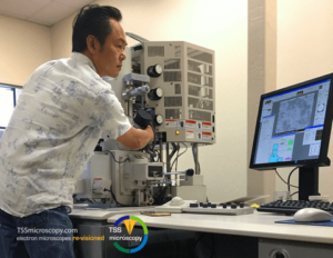 Man adjusting a remanufactured microscope for sale from TSS Microscopy